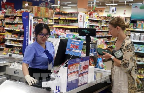Du khách nước ngoài mua hàng hóa tại siêu thị CO.OP mart Rạch Giá, phường Rạch Giá (An Giang). Ảnh: Lê Huy Hải - TTXVN