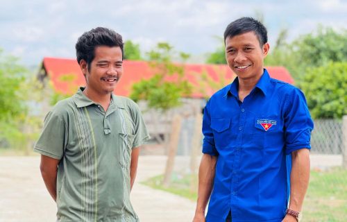 Anh Rmah Mich (bìa phải) nói chuyện với người dân địa phương.