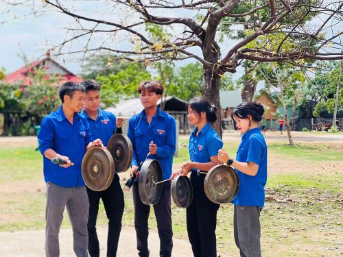 Anh Rmah Mich (bìa trái) hướng dẫn thanh niên cách đánh cồng chiêng. 