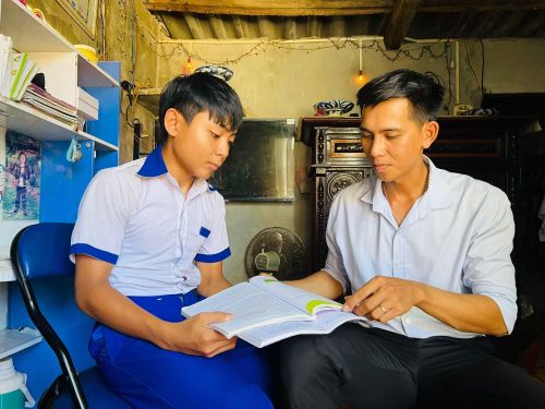 Anh Phan Văn Nhật (bìa phải) giúp đỡ thiếu nhi có hoàn cảnh khó khăn vươn lên trong học tập.