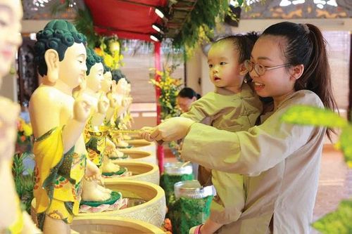 Nguyễn Hoàng Minh Ngọc chỉ vừa tròn 2 tuổi nhưng vui khi đứng trước tôn tượng Đức Phật