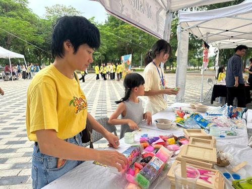 Chị Nguyễn Thị Anh Đào cùng con trải nghiệm các gian hàng tại sự kiện. Ảnh: Ngọc Minh