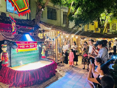 Du khách xem trình diễn rối nước Tế Tiêu. Ảnh: Hoàng Quyên