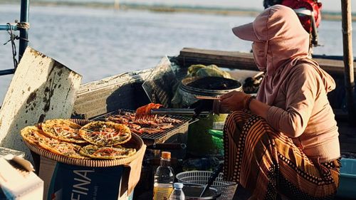 Ngư dân nướng tôm trên ghe phục vụ du khách.