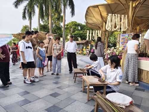 Hình ảnh các bạn nhỏ làng dệt Phùng Xá thực hiện lấy tơ sen tại lễ hội.