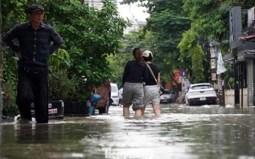 Anh Quân (36 tuổi) cho biết, từ sáng sớm, nhiều người dân trên phố đã phải gọi cứu hộ để kéo ô tô rời đi vì ngập sâu. Một số phương tiện đỗ trên vỉa hè nhưng vẫn bị ngập 20cm.