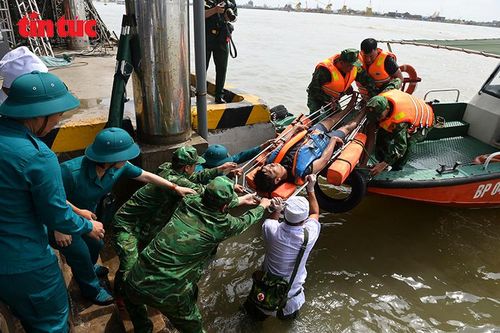 Lực lượng chức năng đưa thuyền viên gặp nạn từ xuồng cứu hộ lên bờ để sơ cứu trong phần thực binh diễn tập.