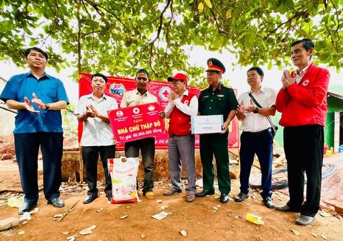  Đại diện các ban, ngành, đoàn thể địa phương trao bảng hỗ trợ xây nhà Chữ thập đỏ và tặng quà cho gia đình ông Siu A (làng Grôn, xã Đức Cơ). Ảnh: N.N 