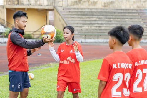 Huấn luyện viên hướng dẫn kỹ thuật cơ bản cho học viên nhí.