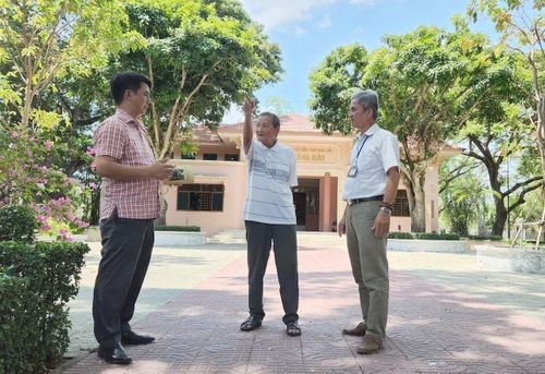 Ông Mười Tiềm, nhân chứng lịch sử (đứng giữa) kể lại quá trình bảo vệ và dựng Đền thờ. Ảnh chụp tháng 4/2023.