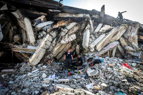 Lực lượng cứu hộ đang tìm kiếm trong tòa nhà bị hư hại. (Ảnh: Reuters)