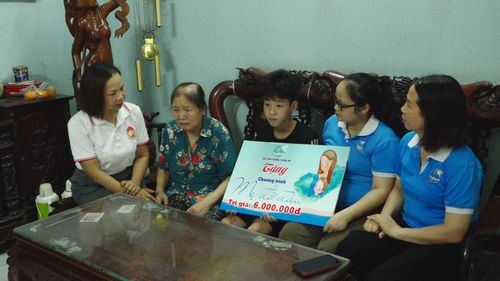 Chủ tịch Ủy ban MTTQ Việt Nam phường Dương Nội Lại Hà Phương trao quà cho gia đình có hoàn cảnh khó khăn. Ảnh Thu Oanh