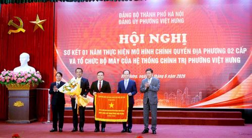 Phó Chủ tịch Thường trực UBND thành phố Hà Nội Dương Đức Tuấn trao Cờ thi đua của Thủ tướng Chính phủ tặng Đảng ủy, chính quyền nhân dân phường Việt Hưng. Ảnh: B.Duy