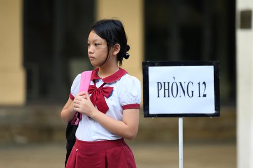Theo hướng dẫn của học sinh tình nguyện, Nguyễn Bùi Minh Chuyên, học sinh trường Trung Tiểu học Việt Anh, di chuyển vào khu vực tập trung trước giờ làm bài. Với Minh Chuyên, chất lượng đào tạo và môi trường học tập là lý do em lựa chọn trường THCS và THPT Trần Đại Nghĩa. Dù áp lực trước tỷ lệ cạnh tranh cao, em nói mẹ luôn động viên chỉ cần làm hết sức, không cần quá đặt nặng chuyện đỗ hay trượt.