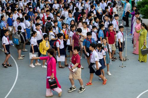 Các học sinh xếp hàng tập trung trong khu vực sân trường. Đúng 7h, từng nhóm học sinh được cán bộ phòng thi hướng dẫn di chuyển lên phòng thi tương ứng. Các em liên tục được nhắc nhở kiểm tra lại phiếu dự thi và thông tin cá nhân để tránh sai sót hoặc đi nhầm điểm thi.