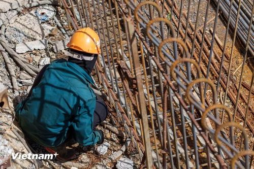 Công đoạn đan lồng thép mố trụ đòi hỏi sự tỉ mỉ, chính xác cao độ dù người thợ phải liên tục phơi mình dưới nắng. (Ảnh: Thanh Phong/Vietnam+)