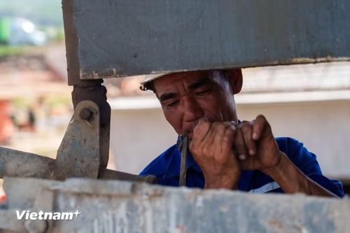 Khuôn mặt sạm đen, nhễ nhại mồ hôi. Bất chấp "chảo lửa" thiêu đốt, họ vẫn miệt mài bám trụ để đảm bảo tiến độ công trình. (Ảnh: Thanh Phong/Vietnam+)