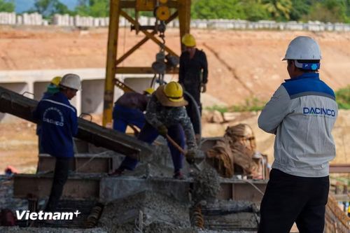 Kỹ sư và công nhân hối hả điều tiết vòi bơm. Tới nay, 14/14 bệ mố trụ của cầu vượt qua Quốc lộ 14B đã thi công xong. (Ảnh: Thanh Phong/Vietnam+)