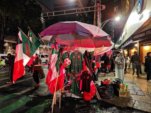 Cờ, mũ, kèn và áo đấu mang màu cờ Mexico được bày bán nhộn nhịp trong trận đấu Mexico- Ecuador. (Ảnh: Phương Lan/TTXVN)