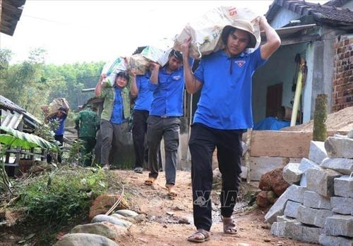 Lực lượng đoàn thanh niên hỗ trợ vận chuyển gạch, đá xây nhà cho người dân khu vực có địa hình dốc tại Chương trình Xóa nhà tạm “đồng lòng vì người khó-gắn kết cộng đồng” của tỉnh Quảng Ngãi. Ảnh: Phạm Cường/TTXVN