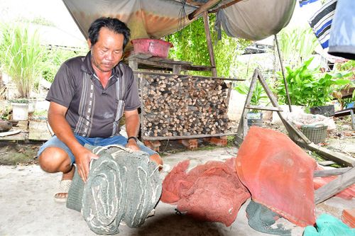 Ông Trương Văn Cỏ xem lại những tấm lưới cũ. Ảnh: BẢO TRÂN