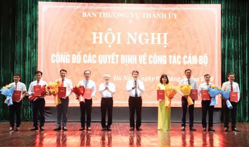 Chủ tịch HĐND thành phố Nguyễn Đức Dũng (thứ 5, bên trái sang) và Phó Bí thư Thành ủy Ngô Xuân Thắng (thứ 5, bên phải sang) trao quyết định và tặng hoa chúc mừng các đồng chí được điều động, bổ nhiệm. Ảnh: NGỌC PHÚ