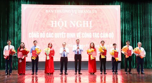 Bí thư Thành ủy Lê Ngọc Quang (thứ 6, bên phải sang) và Phó Bí thư Thường trực Thành ủy Nguyễn Đình Vĩnh (thứ 7, bên phải sang) trao quyết định, tặng hoa chúc mừng các đồng chí được điều động, bổ nhiệm. Ảnh: NGỌC PHÚ