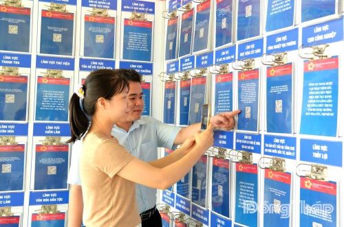 Cán bộ Trung tâm Phục vụ hành chính công xã Tân Phú hướng dẫn người dân tra cứu thủ tục hành chính được số hóa bằng mã QR, góp phần nâng cao hiệu quả cải cách hành chính và tiện ích phục vụ. Ảnh: HẢI ĐĂNG