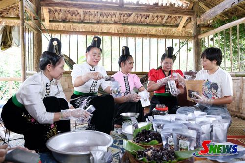 Cán bộ Dự án “Giảm nhẹ và thích ứng với biến đổi khí hậu trong lĩnh vực nông lâm nghiệp vùng núi Tây Bắc” - giai đoạn 2 (bên phải) hướng dẫn người dân xã Muổi Nọi đóng gói sản phẩm Ô mai mận
