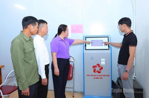 Công chức xã Hồng Thái hướng dẫn người dân lấy số thứ tự tự động khi đến giải quyết thủ tục hành chính.