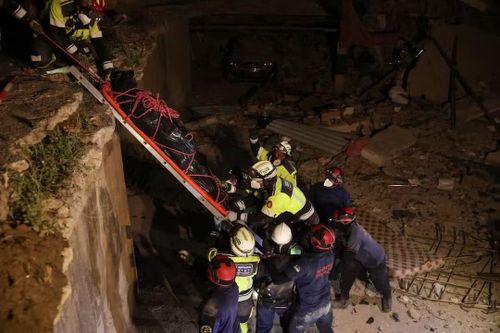 Đội cứu hộ EQ11 đưa thi thể một nạn nhân ra khỏi đống đổ nát. Ảnh: Reuters