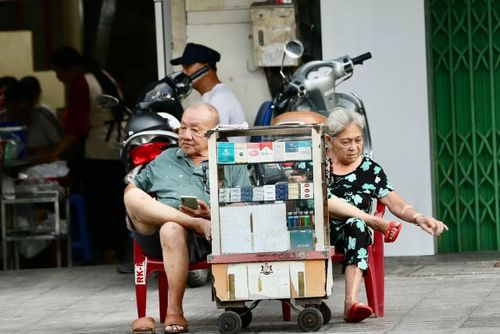 2 vợ chồng già bên tủ thuốc lá trên đường Hậu Giang, một nét xưa vẫn còn hiện diện trên đường phố.