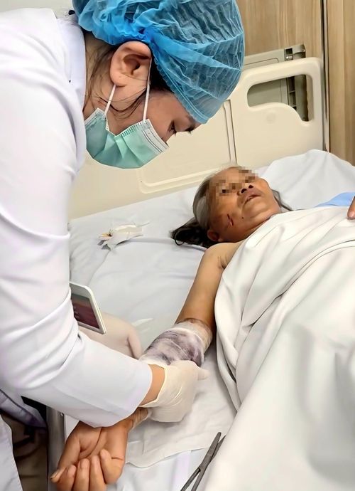 Nhân viên y tế chăm sóc vết thương cho cụ bà.