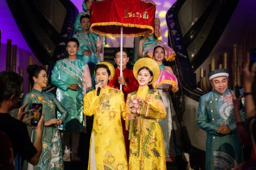 Nghi thức rước dâu truyền thống xuất hiện trên sân khấu với đầy đủ thành phần trong đoàn đón dâu. Trong ảnh, rể phụ cầm lọng che chở cho đôi uyên ương, hai bên là đấng sinh thành cùng đội tráp lễ phía sau.