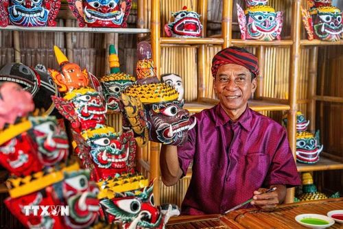 Nghệ nhân ưu tú Kim Mạnh (62 tuổi) xã Tà Cú, tỉnh Vĩnh Long thực hiện các công đoạn chế tác mặt nạ chằn. (Ảnh: Khánh Hòa/TTXVN)
