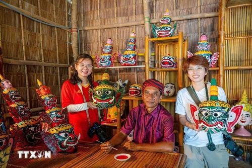 Du khách tìm hiểu nghệ thuật chế tác mặt nạ múa chằn của đồng bào Khmer. (Ảnh: Khánh Hòa/TTXVN)