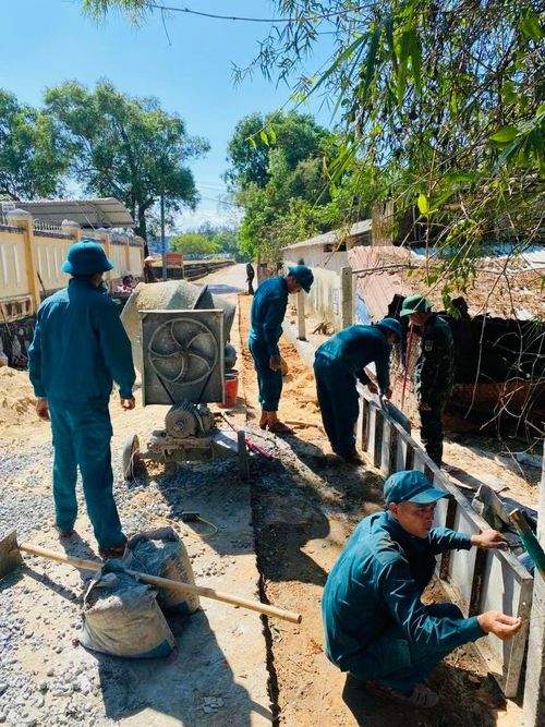 Lực lượng dân quân xã Tam Xuân tham gia hỗ trợ ngày công, góp phần hoàn thiện tuyến đường giao thông nông thôn. Ảnh: P.A
