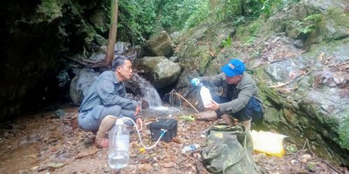 Ông Trần Hữu Vỹ (bên trái), Giám đốc Trung tâm GreenViet lấy mẫu nước để nghiên cứu Sao la theo công nghệ eDNA.