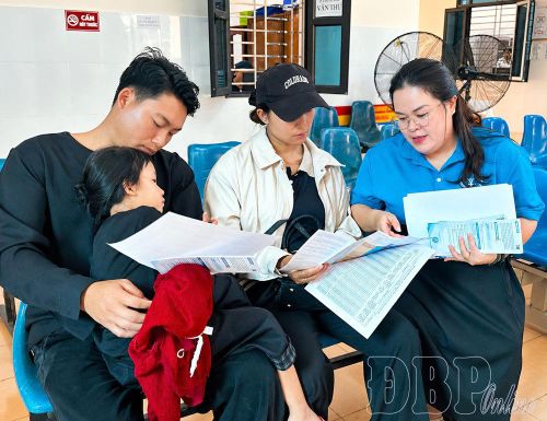Cán bộ Bảo hiểm Xã hội tỉnh tuyên truyền chính sách bảo hiểm y tế mới tới người dân. Ảnh: Thu Hằng