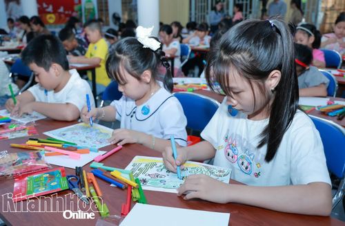 Các em nhỏ lứa tuổi tiểu học tập trung tô màu cho bài thi của mình.