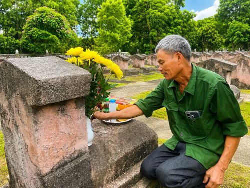 Ông Nguyễn Trọng Bảy bên phần mộ anh trai là liệt sĩ Nguyễn Trọng Khánh, an táng tại nghĩa trang xã Triệu Sơn.