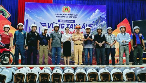 Lãnh đạo Phòng CSGT và UBND xã Bến Giằng trao mũ bảo hiểm đạt chuẩn tặng người dân.