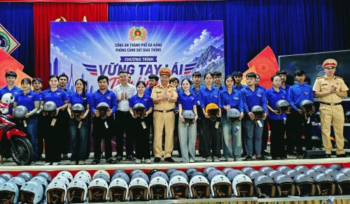 Lãnh đạo Phòng CSGT và đại biểu trao mũ bảo hiểm tặng đoàn viên, thanh niên xã Bến Giằng.