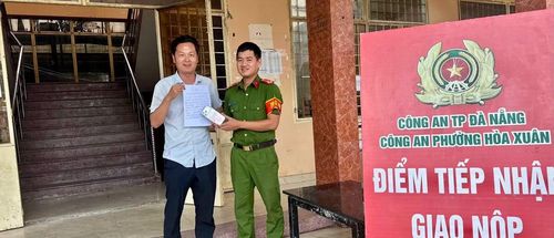 Nam du khách người Trung Quốc vui mừng khi nhận được điện thoại bị đánh rơi từ tay cán bộ Công an phường Hòa Xuân.