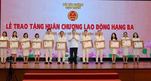 Thừa ủy quyền của Chủ tịch nước, Thứ trưởng Bộ Tài chính Cao Anh Tuấn trao Huân chương Lao động cho các tập thể, cá nhân - Ảnh: VGP