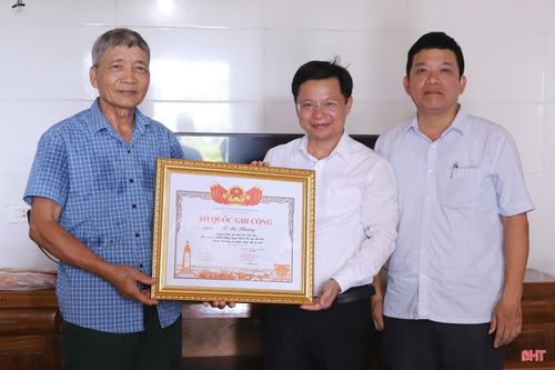 Ông Lê Bá Vựng (bên trái) đón nhận bằng "Tổ quốc ghi công" liệt sĩ Lê Bá Phương.