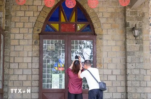 Du khách đến tham quan, tìm hiểu về kiến trúc, văn hóa tại nhà thờ Đạ Tông. (Ảnh: Nguyễn Dũng/TTXVN)
