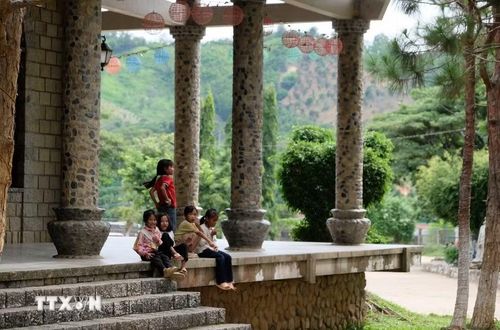 Nhà thờ Đạ Tông mở cửa tự do cho khách tham quan, cho các em nhỏ người địa phương đến vui chơi trong không gian rộng rãi, xanh mát giữa mùa hè. (Ảnh: Nguyễn Dũng/TTXVN)