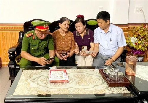 Hướng dẫn người dân sử dụng các tiện ích số trên điện thoại thông minh. Ảnh: Minh Tâm - TTXVN