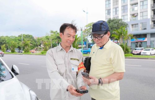 Khách hàng tại bãi trông giữ xe của Công ty CP Phát triển Uy Nguyên (phố Hội Xá, phường Phúc Lợi) cho biết, việc thu phí ETC thuận tiện và linh hoạt hơn nhiều so với phương thức thanh toán tiền mặt trước đây. Ảnh: Tiến Long/ TTXVN phát
